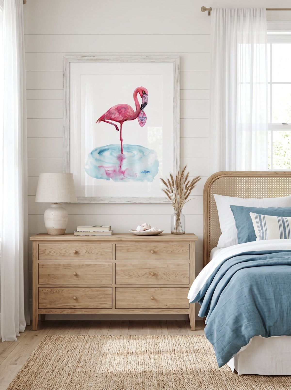 A watercolor painting titled "Flamingo Motel davidkjonesart.jpg", featuring a pink flamingo standing on one leg in a shallow pool of light blue water with its pink reflection visible below. The flamingo is holding a retro pink motel keychain in its beak with the text "Flamingo Motel Room 7". The artwork is signed by the artist in the bottom right corner.